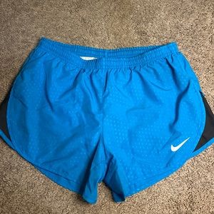 Blue Nike dri-fit athletic shorts with gray stripe